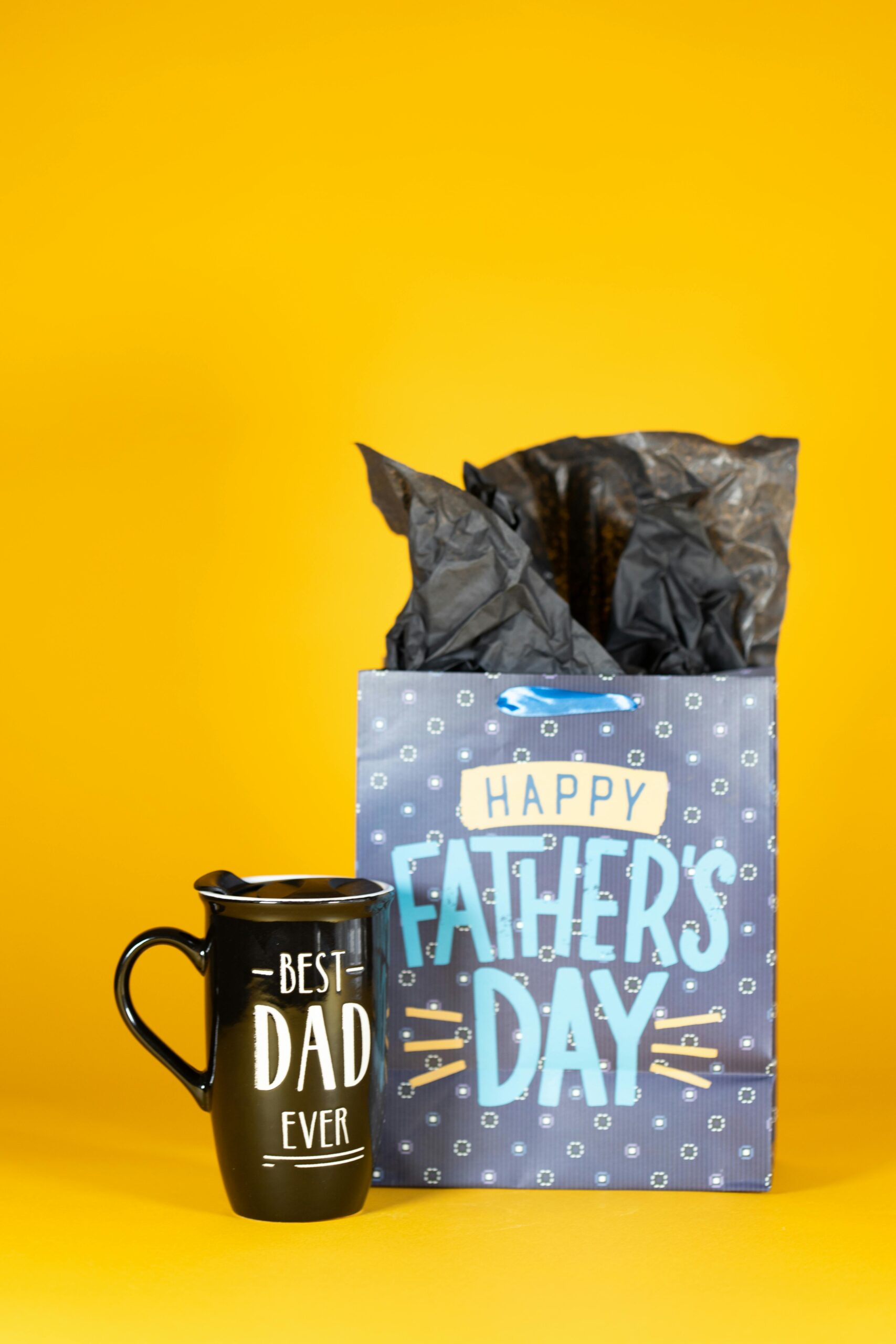 Sac cadeau noir et tasse pour la fête des pères sur fond jaune